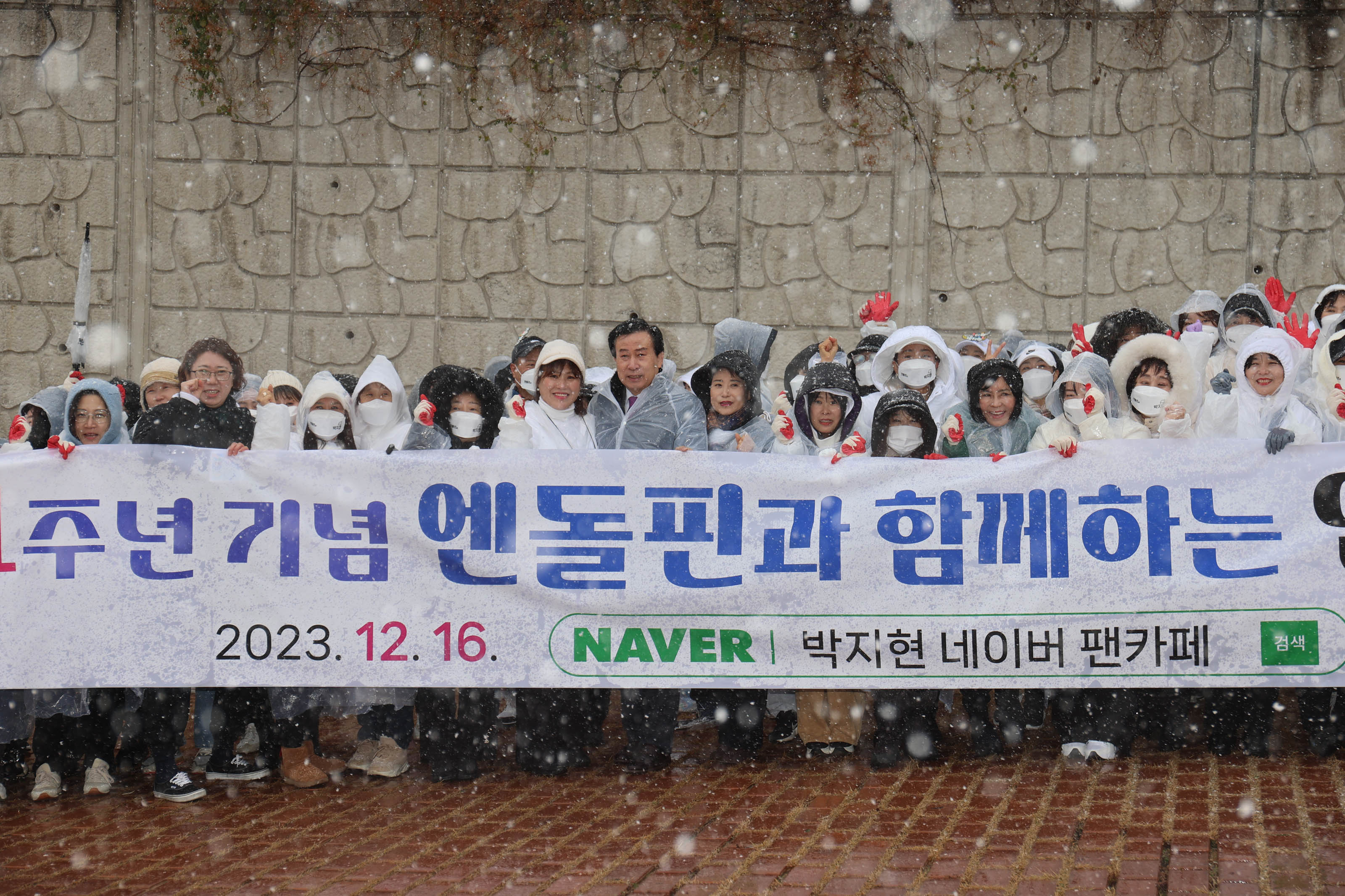 엔돌핀과 함께하는 2023.12.16 박지현 네이버 팬카페가 적힌 플랜카드를 들고 눈내리는 배경과함께 서있는 봉사단과 박홍률 목포시장
