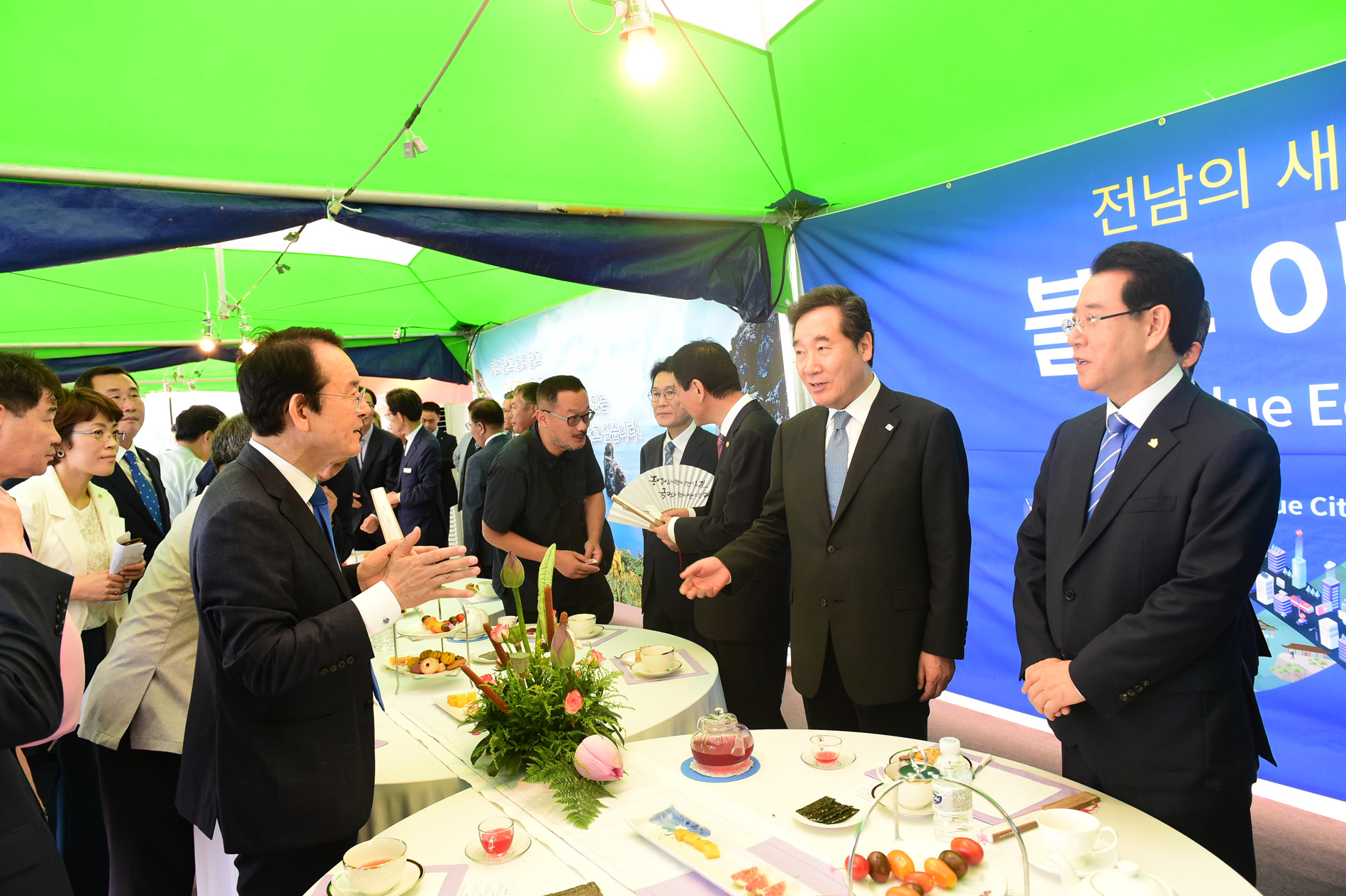 차와 과일, 과자 등이 놓여있는 테이블을 사이에 두고 대화를 나누고 있는 목포시장과 국무총리